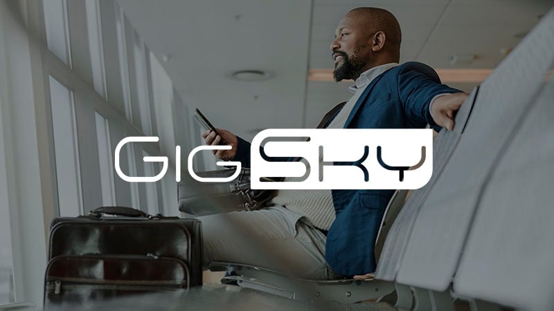 Man relaxing in airport lounge with GigSky logo superimposed.